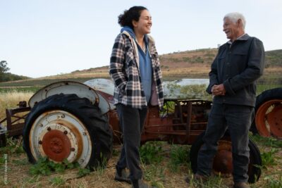 Mike and Niloofar have very different backgrounds, coming from Mexico and Iran respectively, and they share a love of farming. Here they laugh about the history of one of Mike's retired tractors.